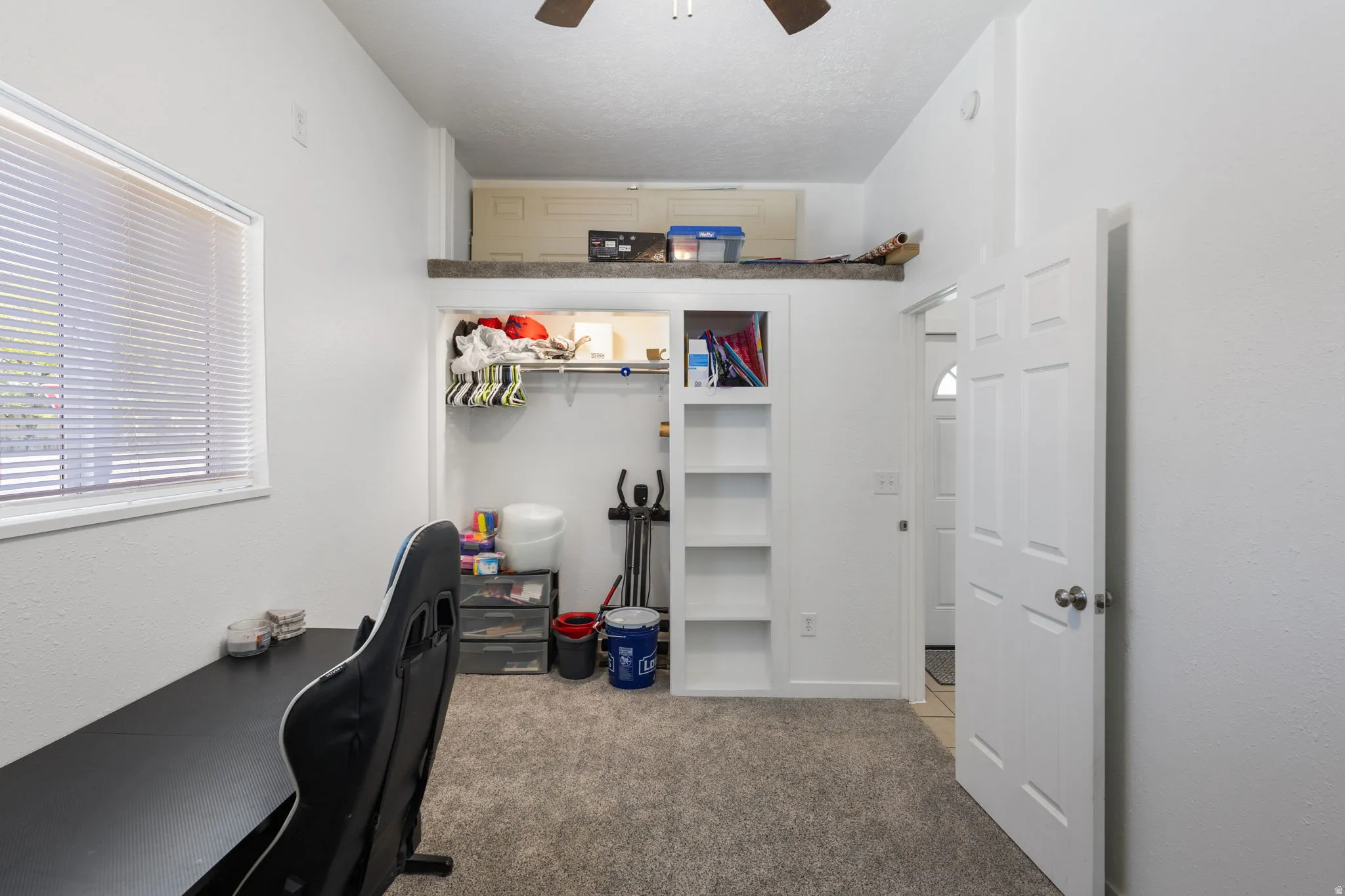 Office area featuring light colored carpet and ceiling fan
