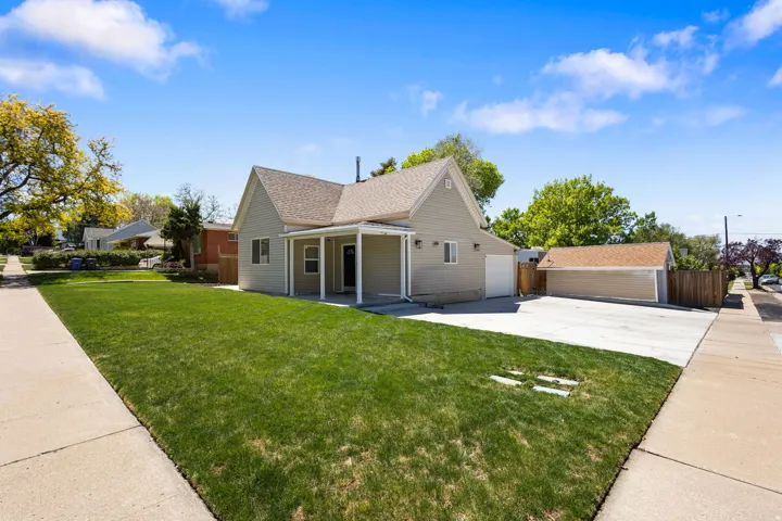View of front of home featuring covered porch, concrete driveway, and a shingled roof