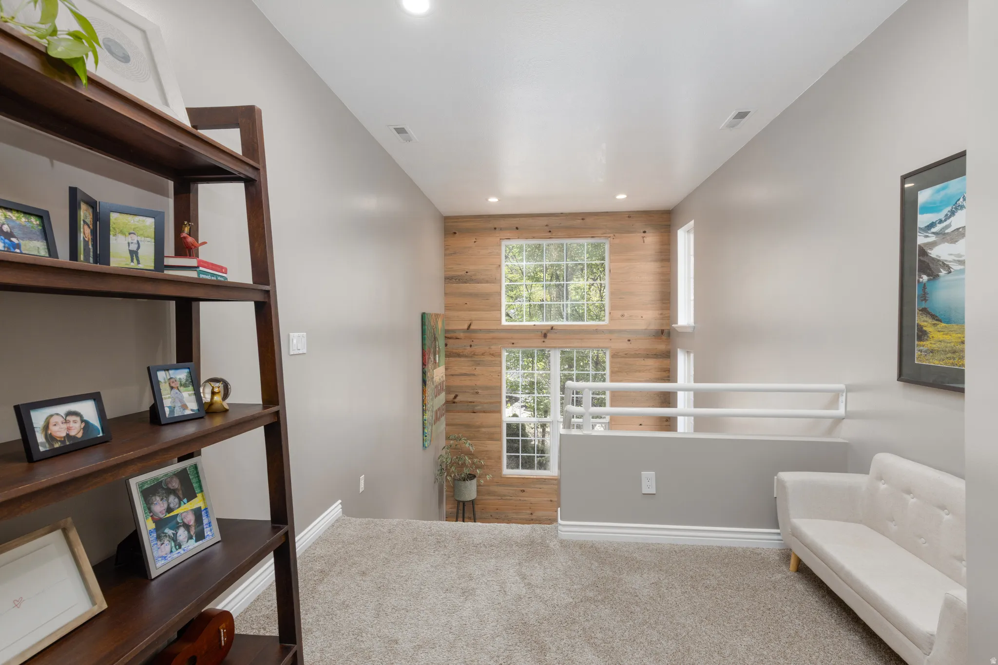 Sitting room with wooden walls, recessed lighting, and carpet flooring