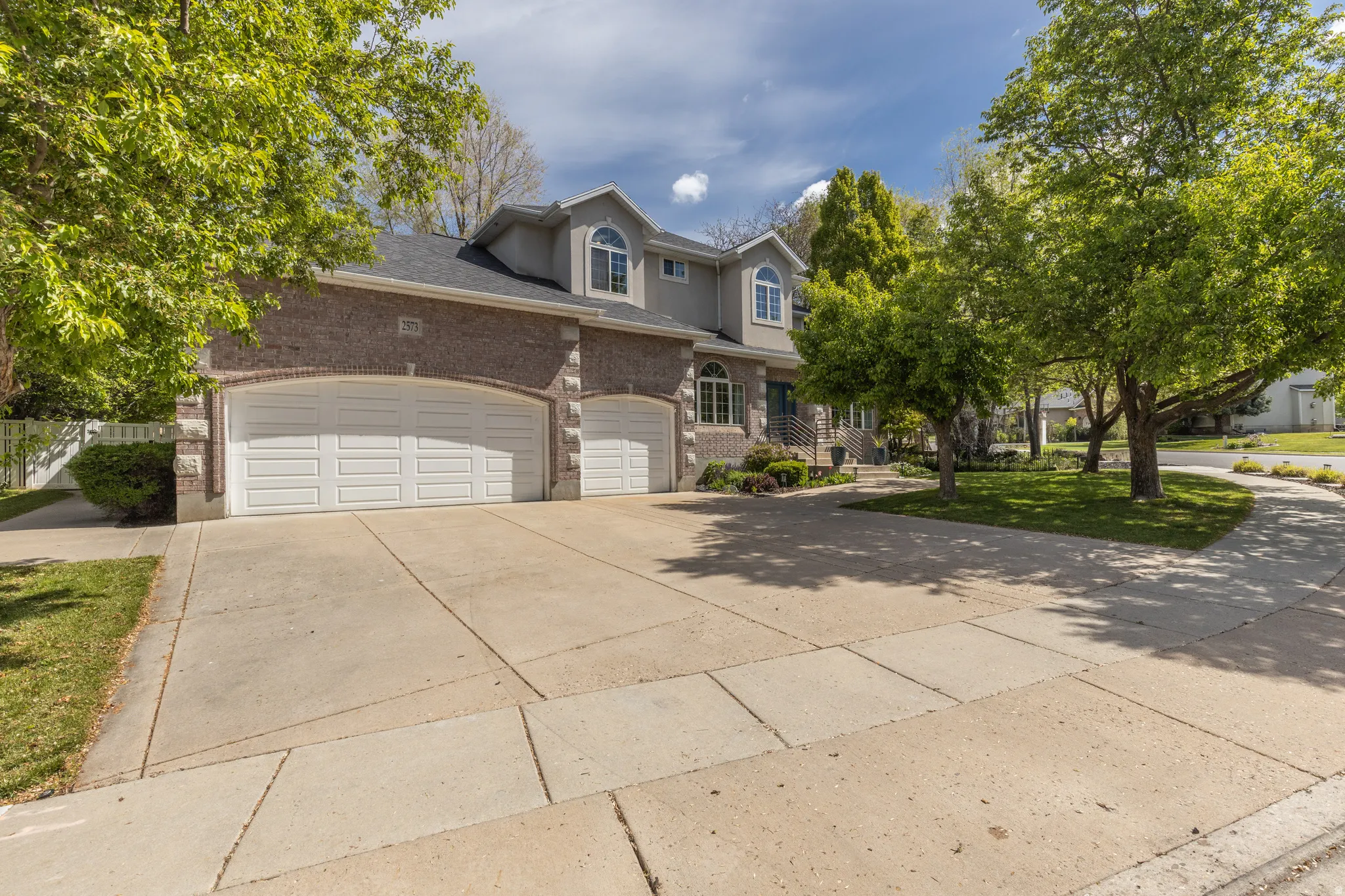 Traditional-style house with brick siding, concrete driveway, a garage, and a shingled roof