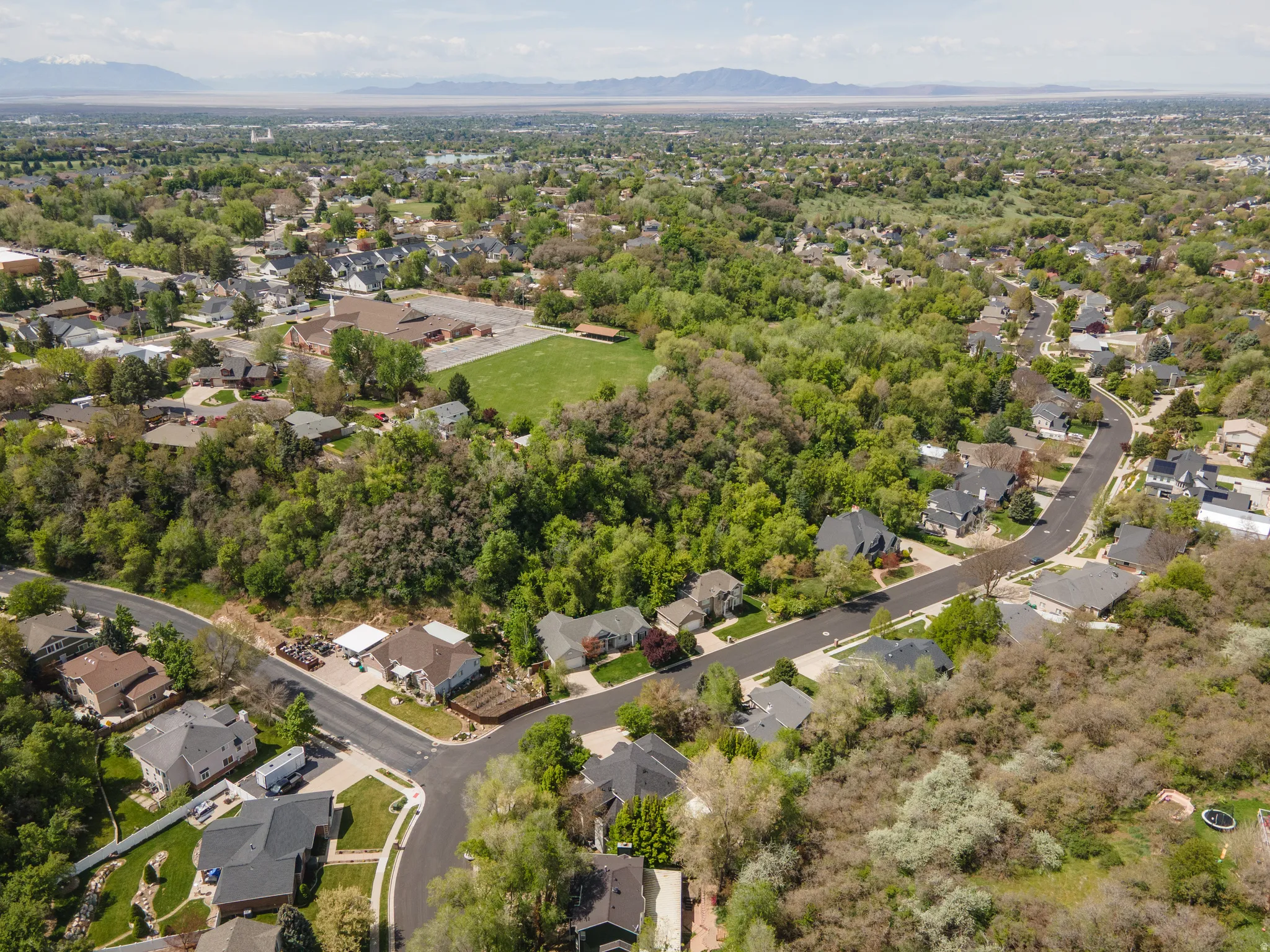 Aerial view of property and surrounding area with mountains and nearby suburban area