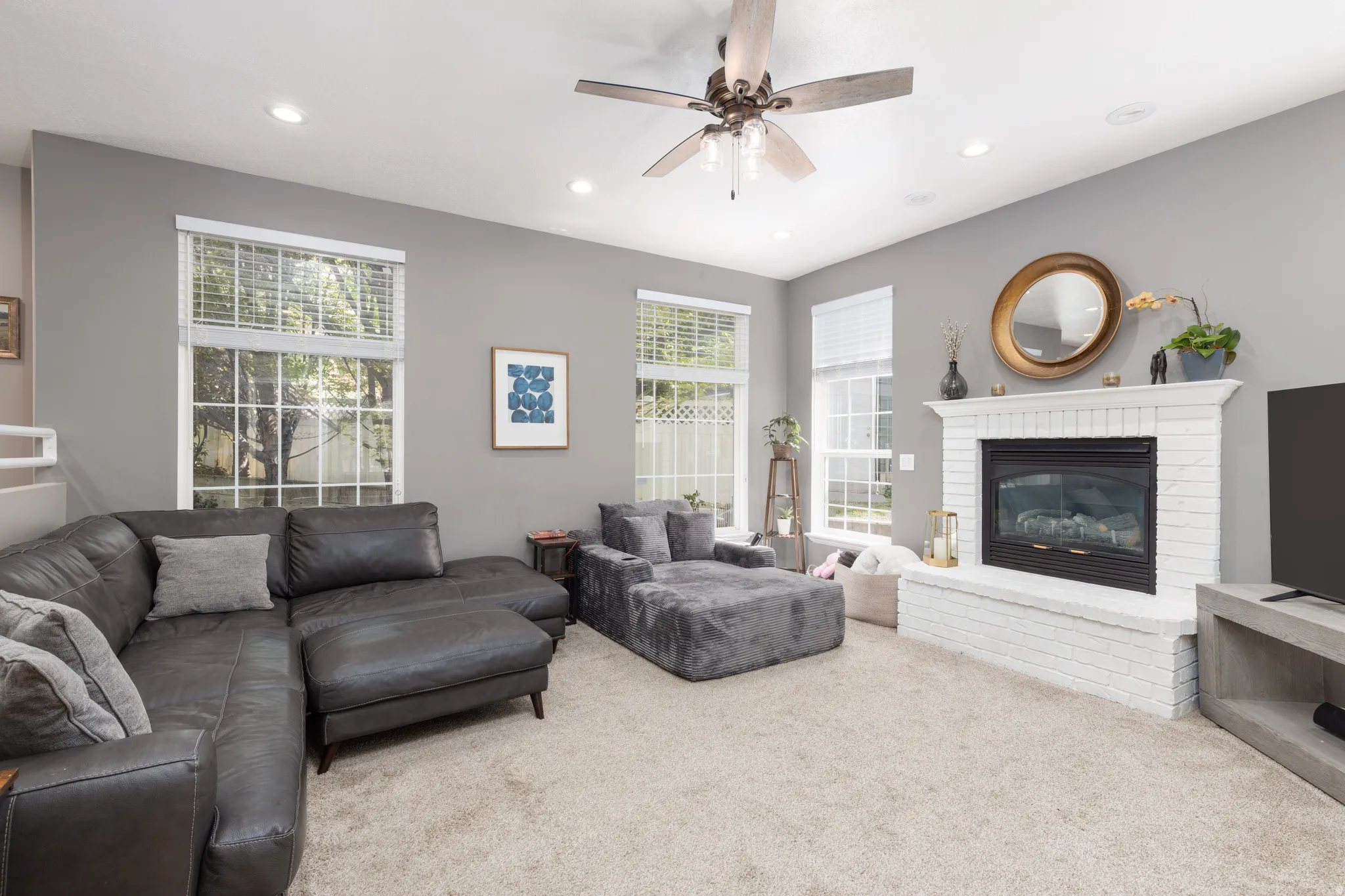 Living area with ceiling fan, carpet floors, a brick fireplace, plenty of natural light, and recessed lighting