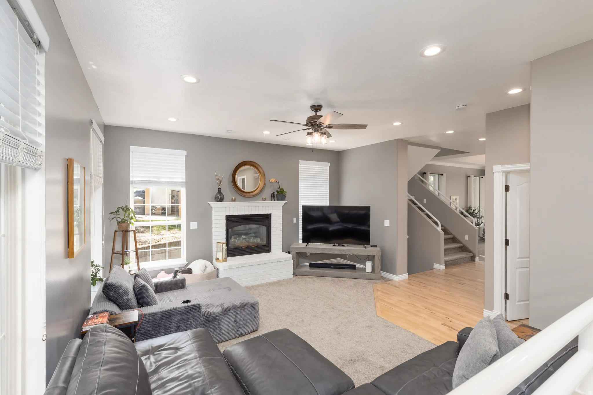Living area featuring ceiling fan, a brick fireplace, recessed lighting, and light wood-type flooring