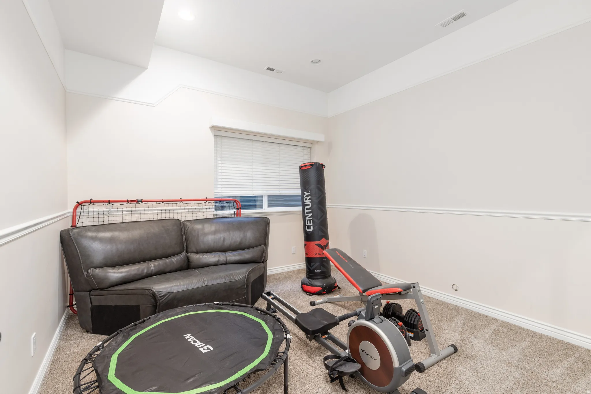 Workout room featuring light colored carpet and baseboards
