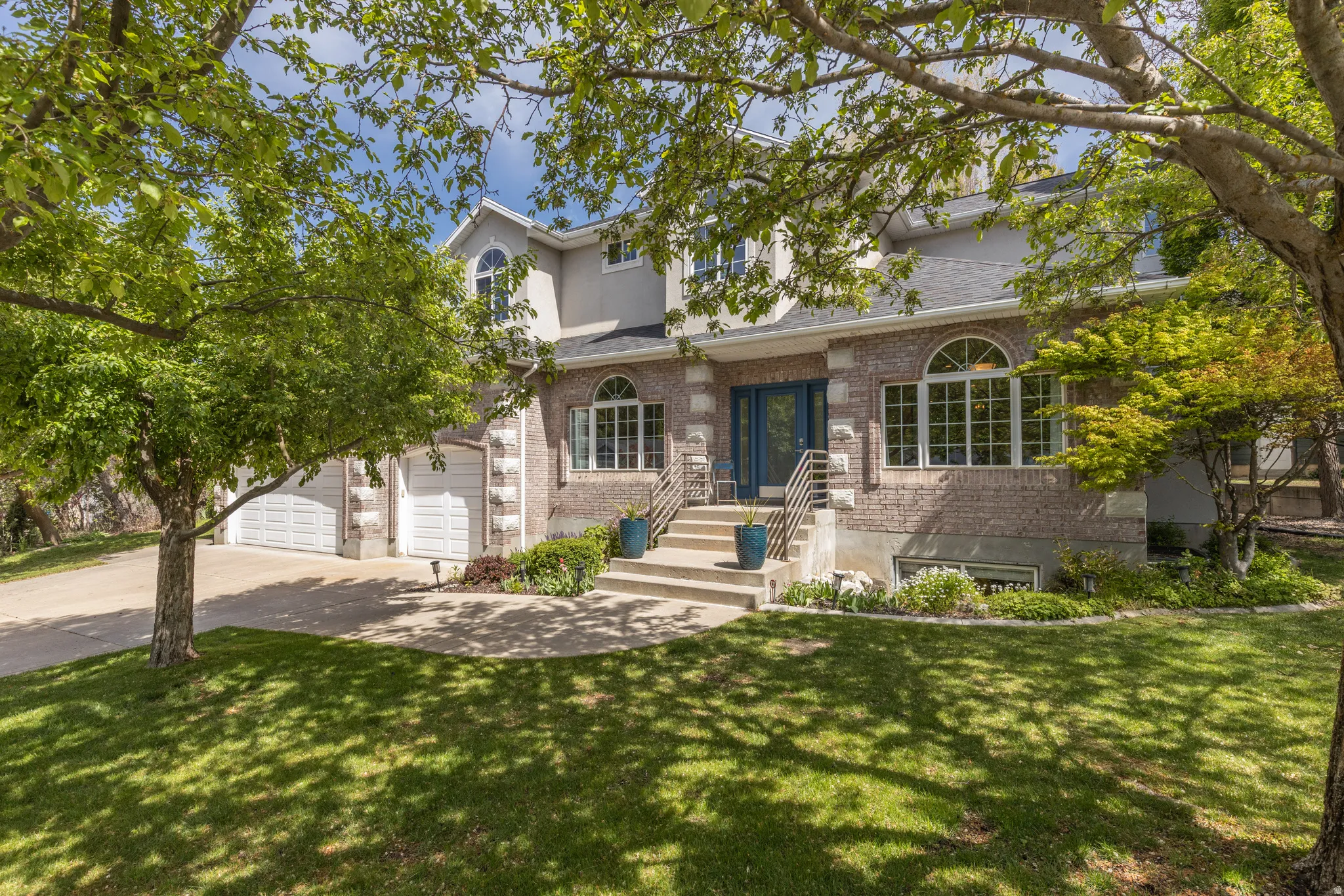Traditional home featuring driveway, a front yard, brick siding, and a shingled roof
