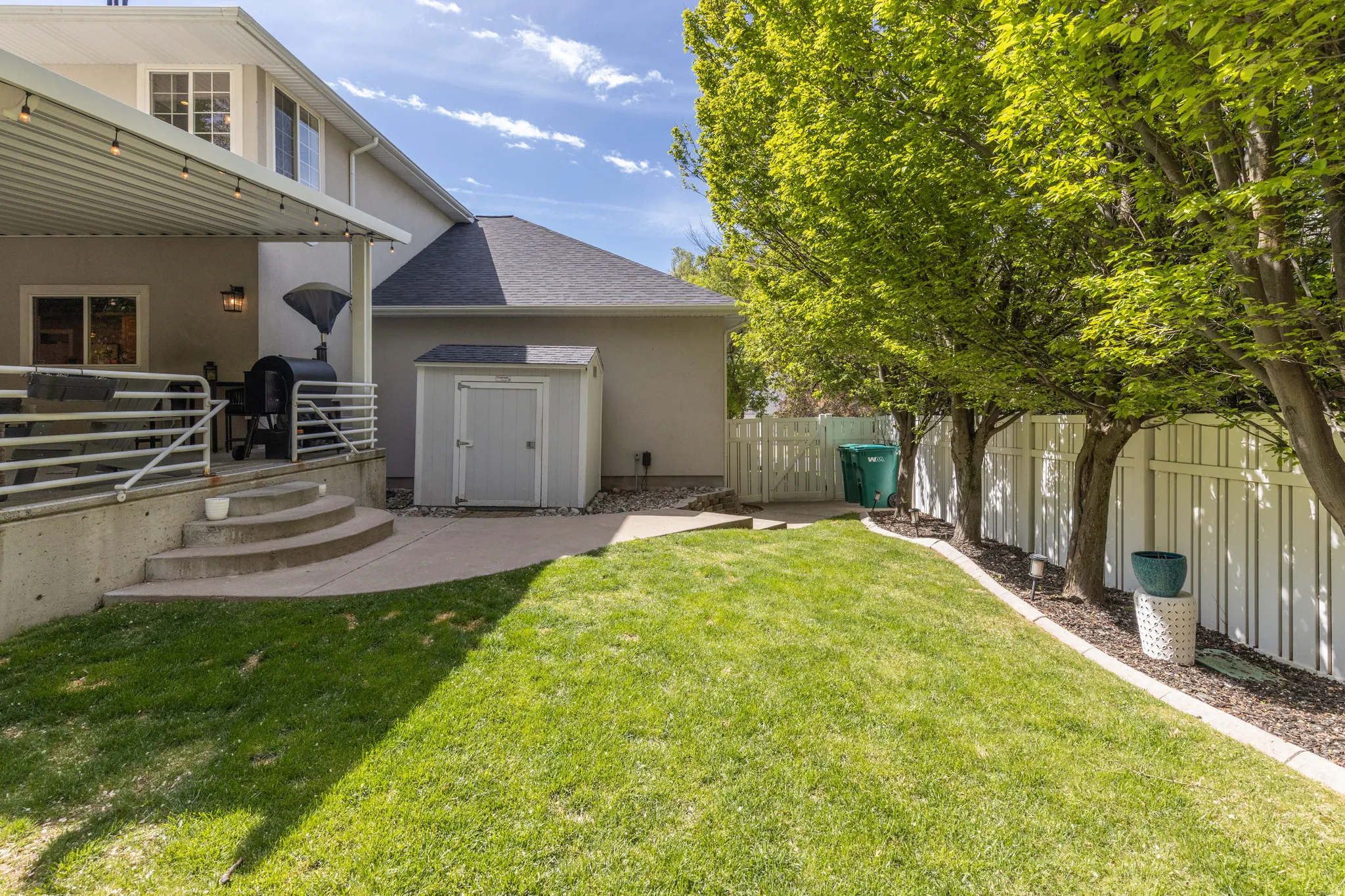 Fenced backyard featuring a patio area and a storage shed
