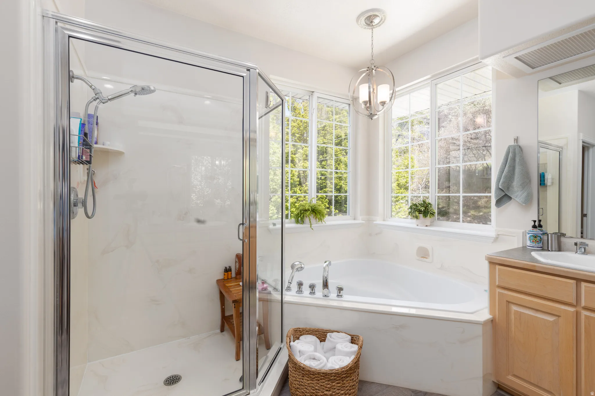 Master bathroom featuring vanity, a bath, and a marble finish shower