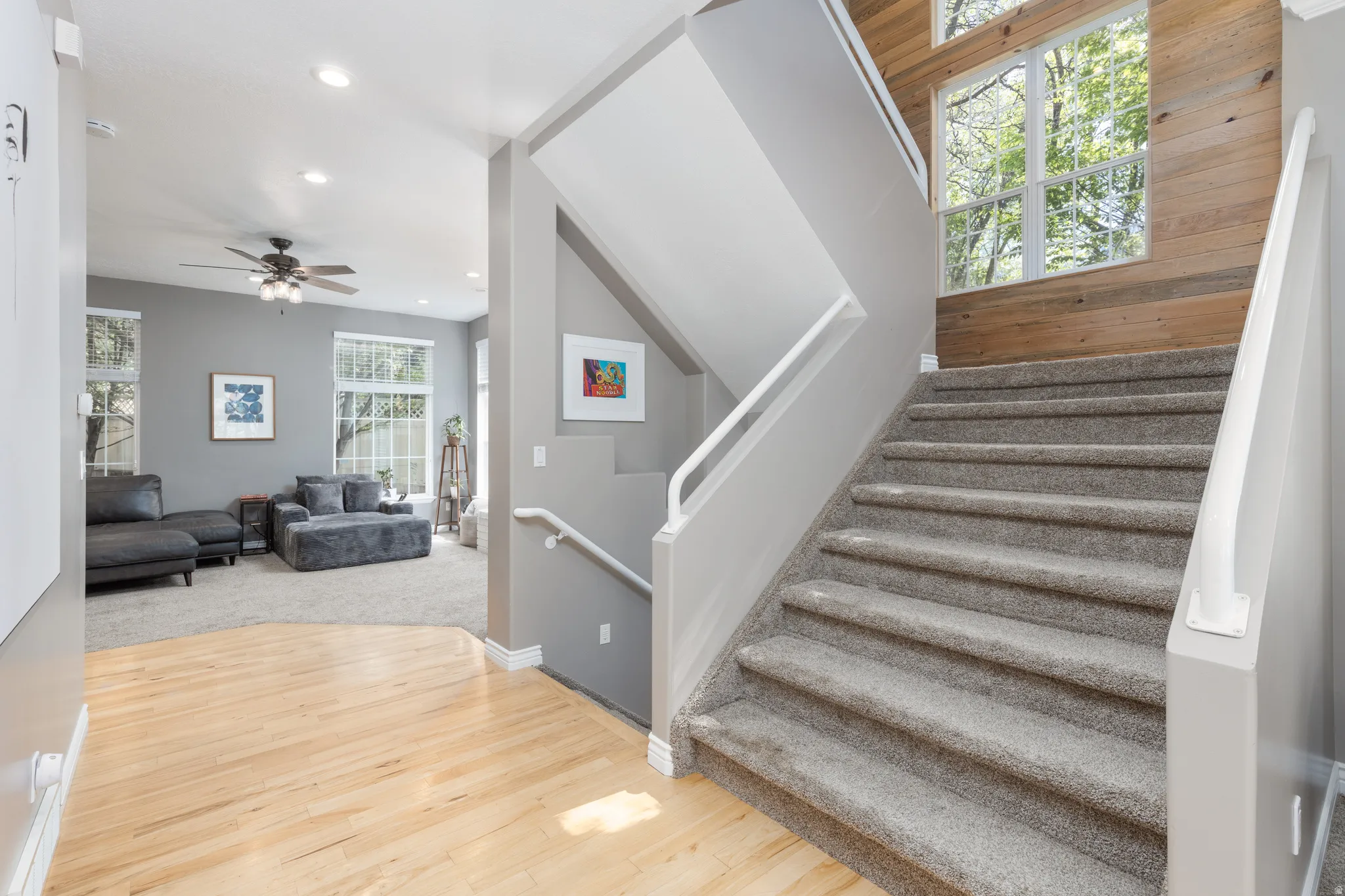 Stairs with wood finished floors, recessed lighting, and a ceiling fan