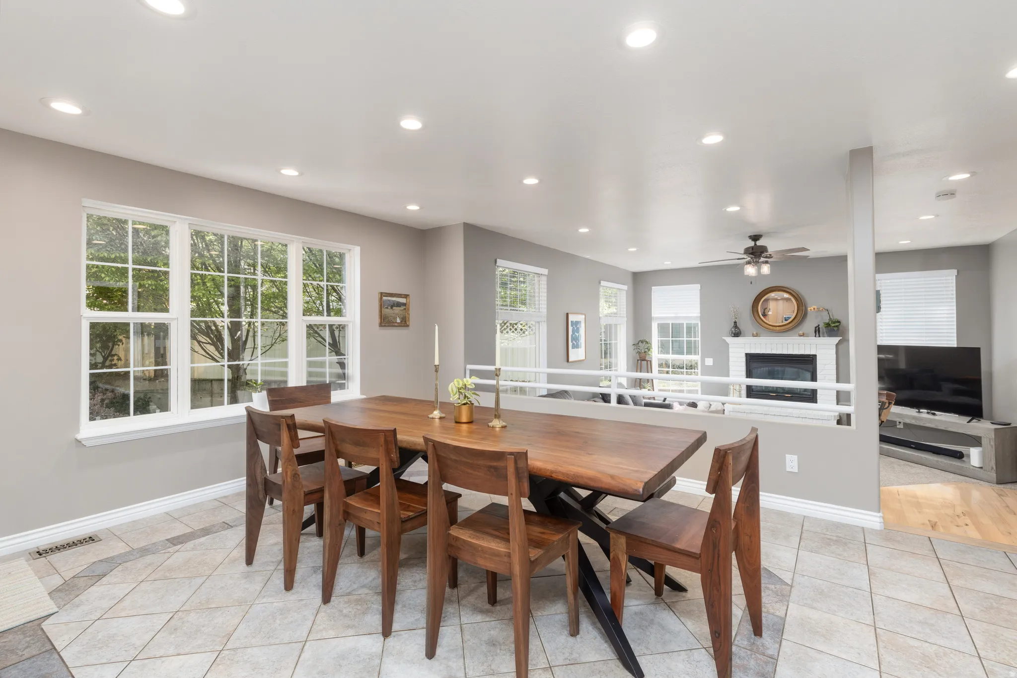 Dining space featuring a fireplace, light tile patterned floors, recessed lighting, and ceiling fan