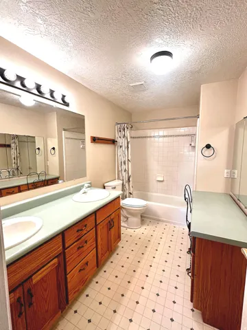 Bathroom featuring a dual vanity with wood cabinetry and light-colored countertops