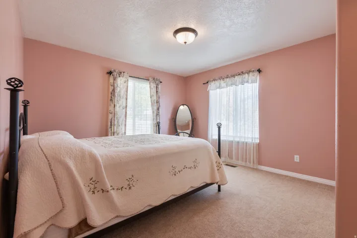 Bedroom featuring light colored carpet and a textured ceiling