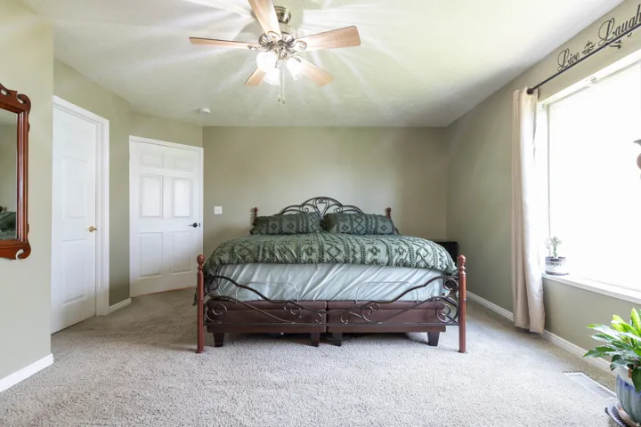 Bedroom featuring light colored carpet, ceiling fan, and a textured ceiling