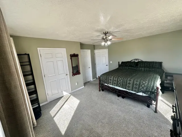 Spacious room featuring neutral carpeting and light green painted walls