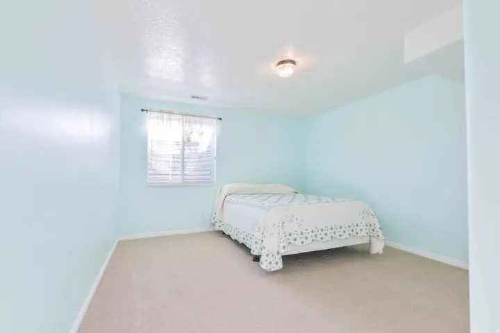 Bedroom with light carpet and a textured ceiling