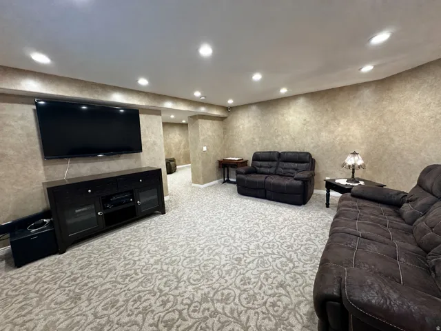 Recessed ceiling lighting illuminates a patterned carpet and textured wall finishes