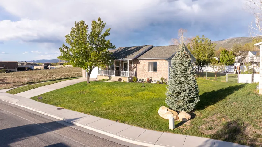 Ranch-style home with brick siding, a mountain view, a porch, and roof with shingles