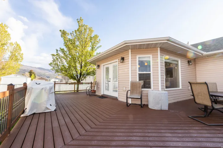 Wooden terrace with french doors and a grill