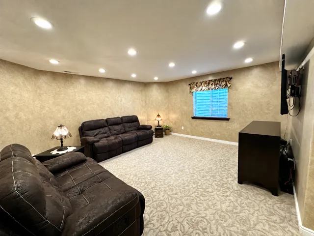 Recessed lighting throughout, textured wall finish, and patterned carpeting