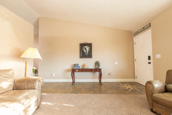 Sitting room with vaulted ceiling and carpet