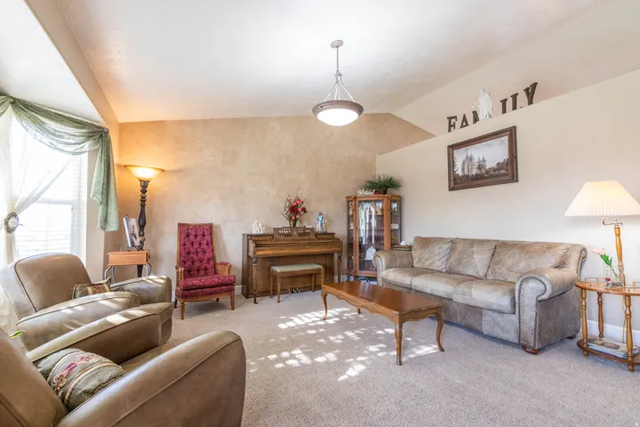 Living area with lofted ceiling and carpet floors