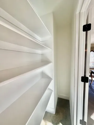 Built-in shelving unit featuring multiple levels of storage and a white finish