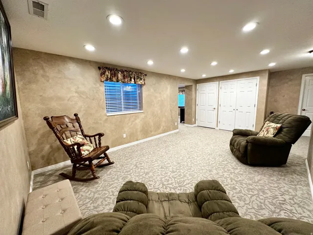 Spacious room featuring patterned carpet flooring, recessed ceiling lighting, and a window with blinds