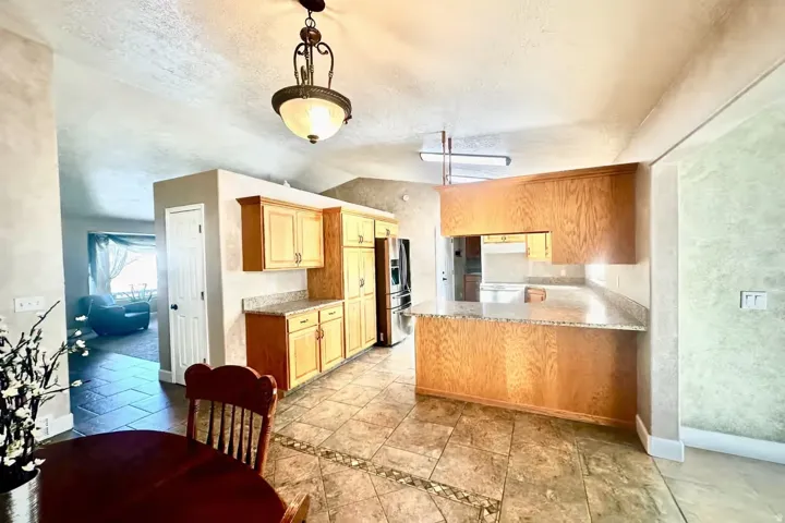 Kitchen featuring wood cabinetry, light-toned countertops, and tile flooring with decorative accents