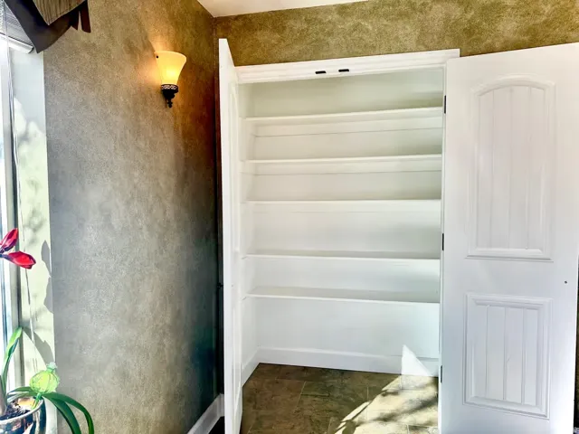 Built-in shelving unit with multiple storage tiers and white paneled doors