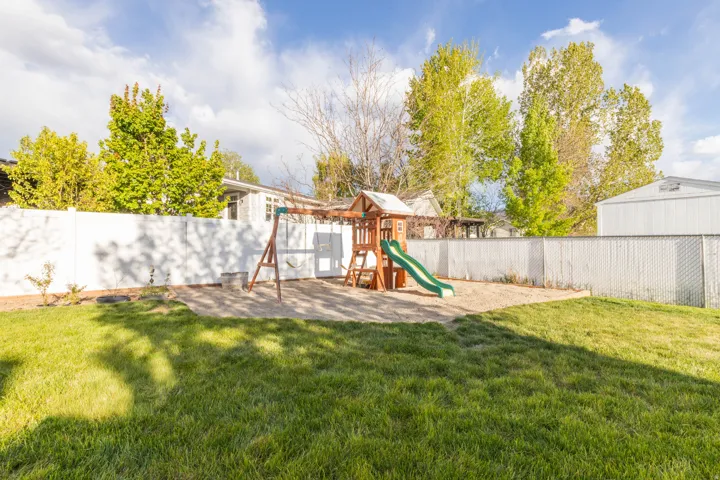 Fenced backyard with a playground
