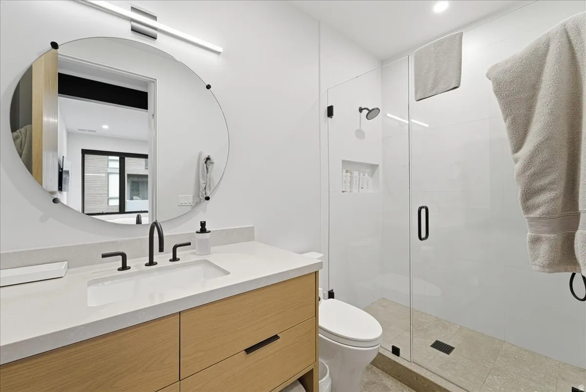 Bathroom featuring vanity, recessed lighting, and a shower stall