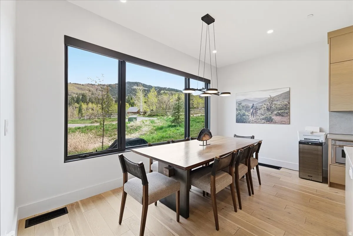 Dining area with light wood-style flooring, a mountain view, and recessed lighting