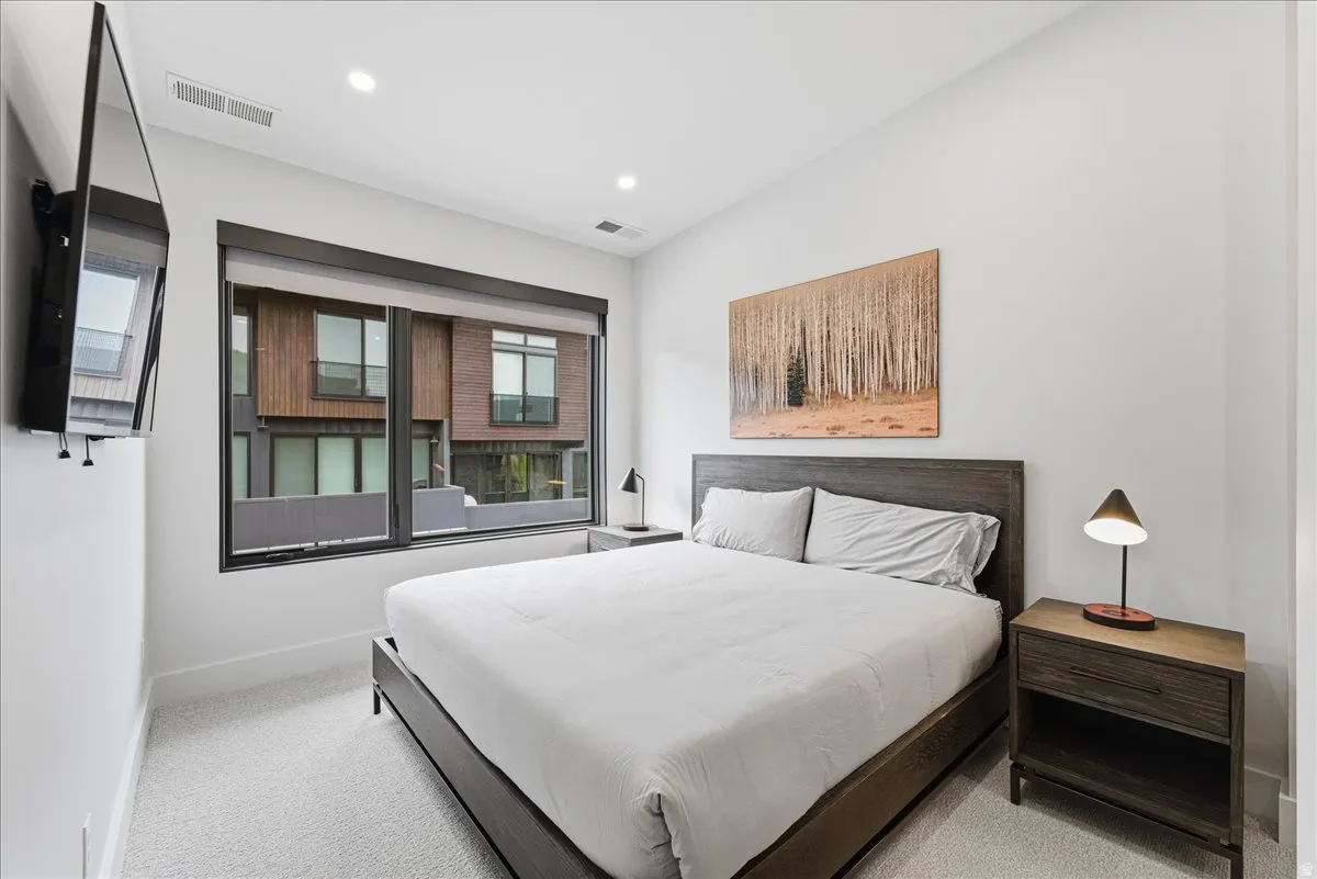 Bedroom with light colored carpet and recessed lighting