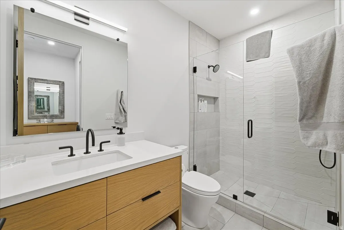 Bathroom with vanity, a shower stall, and recessed lighting