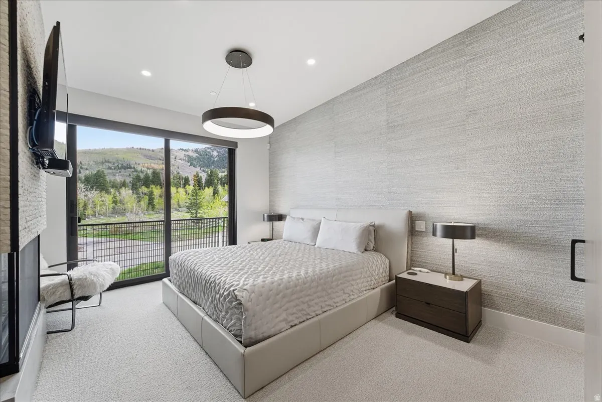 Bedroom featuring an accent wall, light carpet, recessed lighting, and wallpapered walls