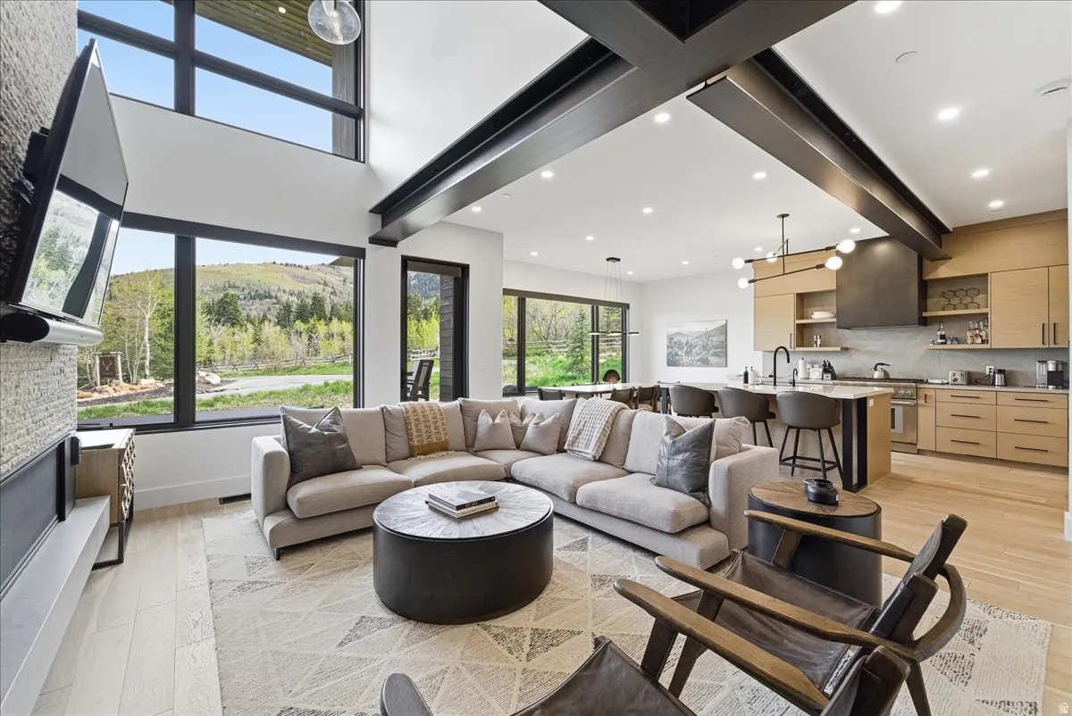 Living area featuring light wood-style floors, beam ceiling, and recessed lighting