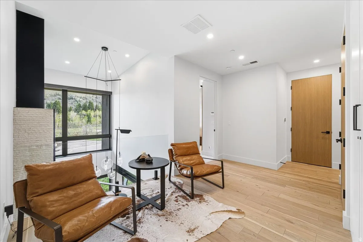 Sitting room with light wood-type flooring and recessed lighting