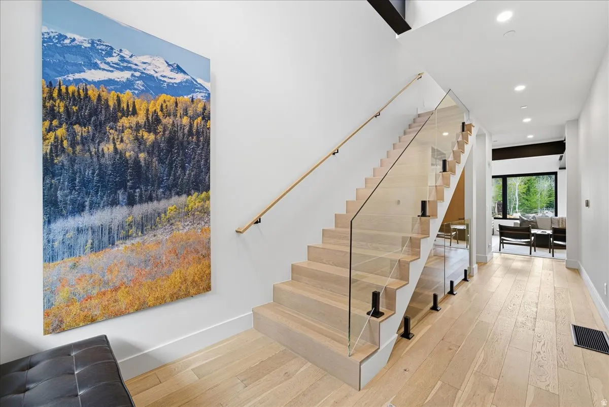 Staircase featuring wood-type flooring and recessed lighting