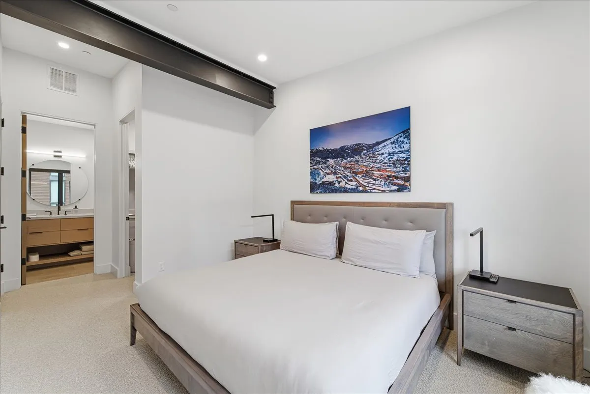 Bedroom with light carpet, ensuite bathroom, and recessed lighting