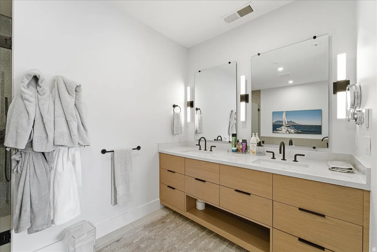 Bathroom featuring double vanity and baseboards