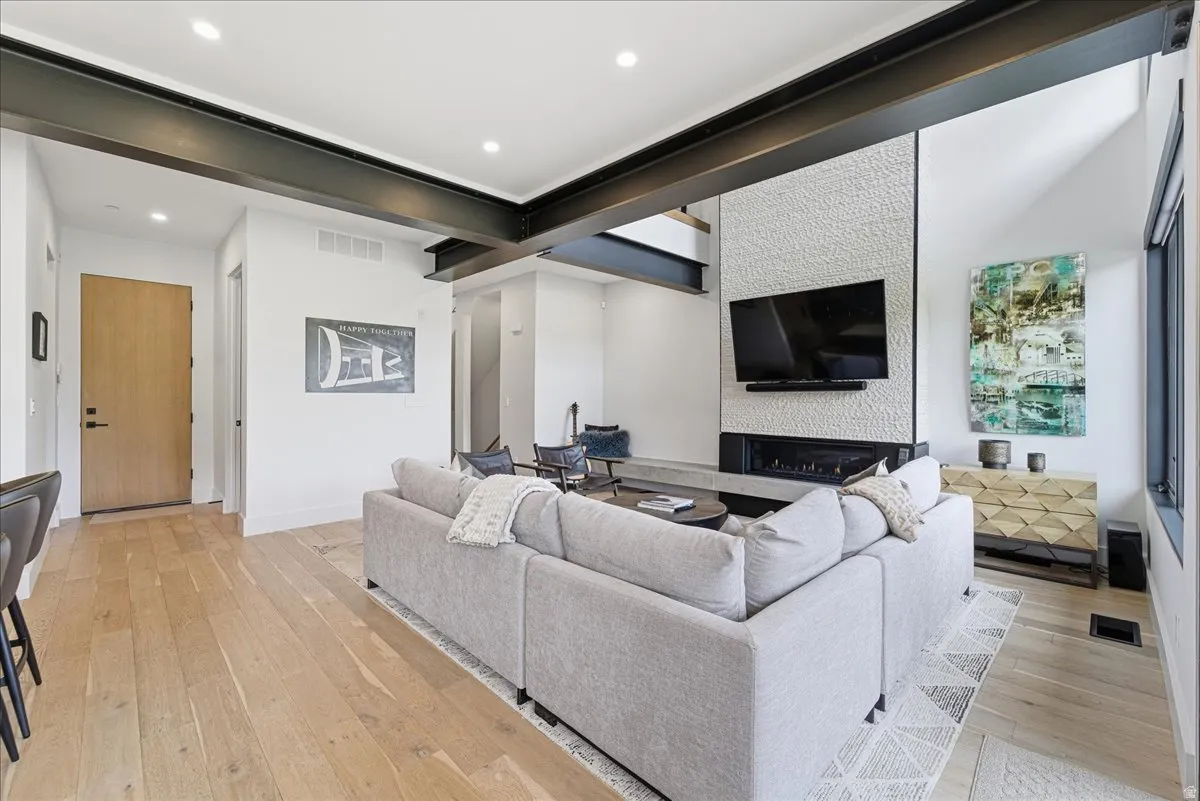 Living room featuring light wood-type flooring, recessed lighting, and a fireplace