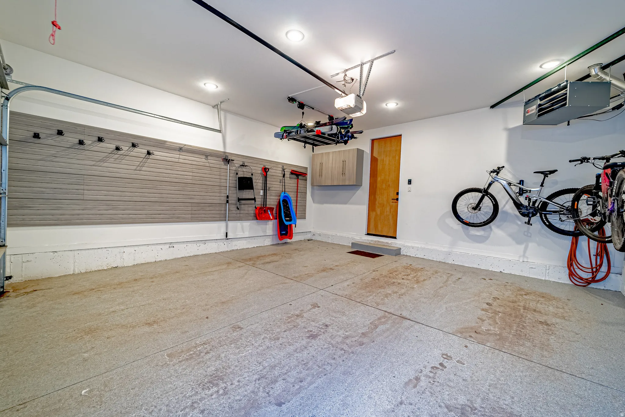 Garage with a heating unit, recessed lighting, and a garage door opener