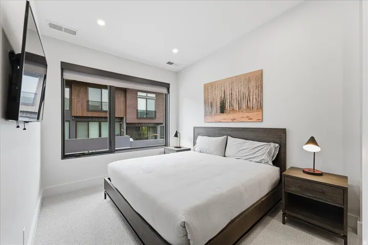 Bedroom with light colored carpet and recessed lighting