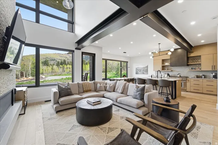 Living area featuring light wood-style floors, beam ceiling, and recessed lighting