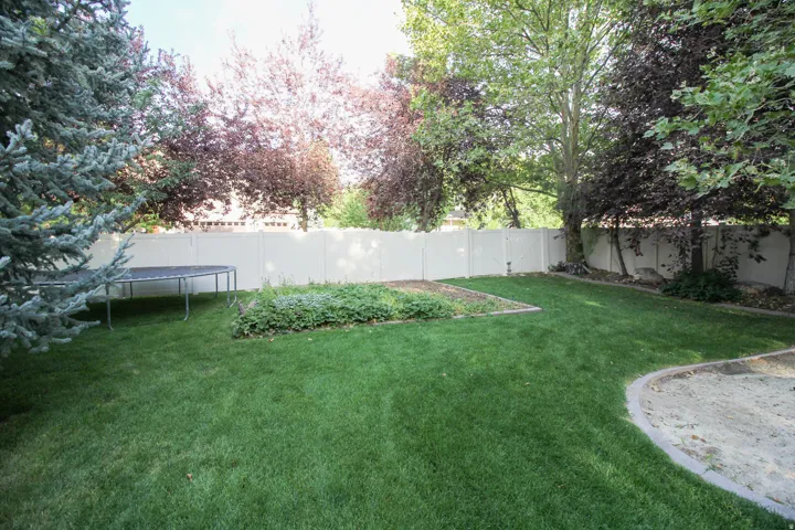 Fenced backyard with a trampoline