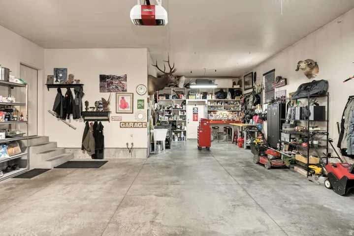 Spacious garage featuring a concrete floor, overhead lighting, and an automatic garage door opener