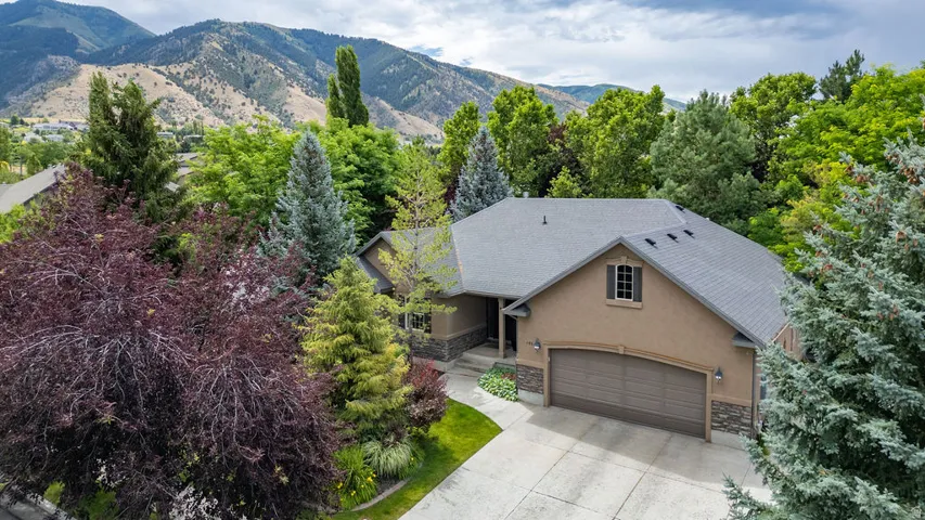 Sleek tan stucco exterior with stone accents and a dark-toned roof
