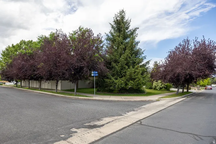 Corner lot featuring mature trees and a white privacy fence