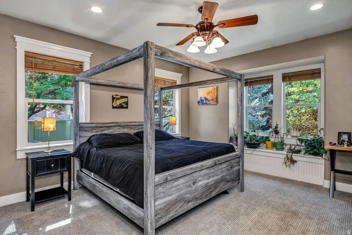 Expansive room featuring multiple windows with wood blinds, neutral-toned walls, and plush carpeting