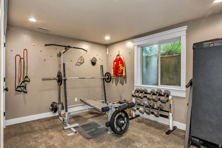 Carpeted room with recessed lighting and a single window featuring white trim