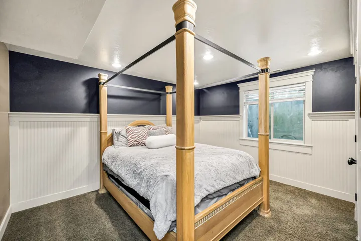 Bedroom featuring beadboard wainscoting, crown molding, and recessed lighting